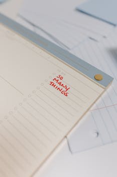 Close-up of a to-do list notepad with 'So Many Things' written, providing copyspace for text.