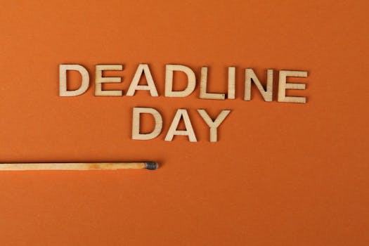 Conceptual image of a deadline with wooden letters and burnt matchstick on orange background.